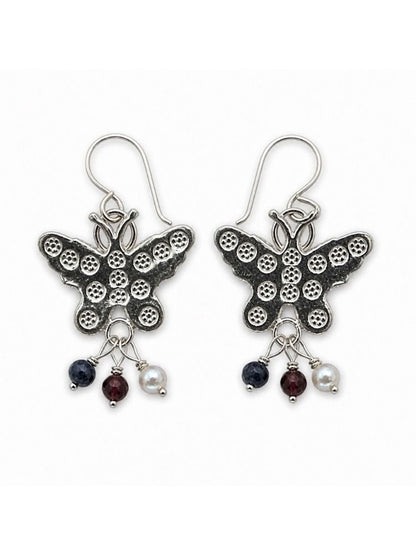 A pair of silver butterfly drop earrings with textured wings and dangling charms including dark blue, burgundy, and white beads, shown on a plain white background.